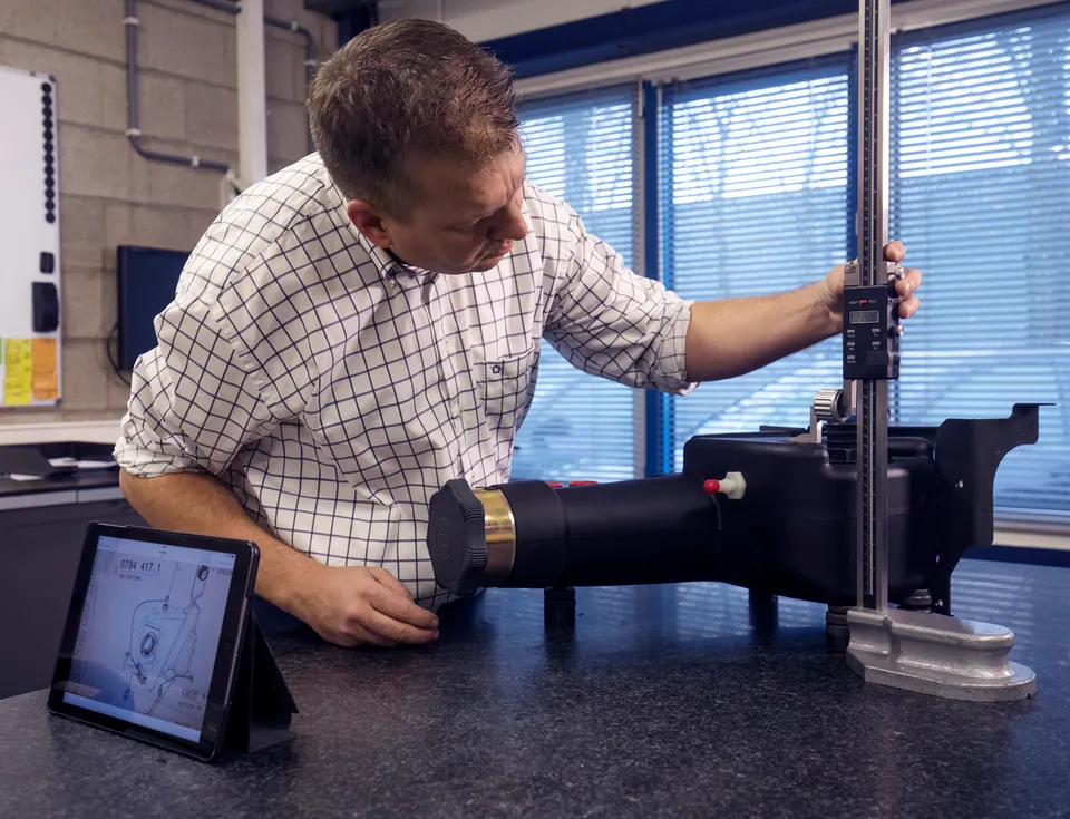 A colleague measuring a moulded product with a digital height gauge.